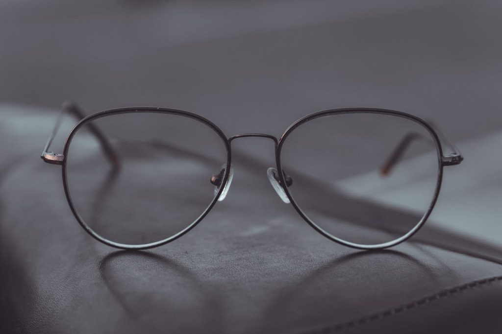 Stylish aviator glasses resting on a leather surface, showcasing sleek design.